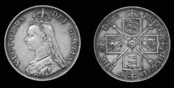 A silver pound of Queen Victoria, dated 1887, with the crest of the House of Hanover on the reverse.