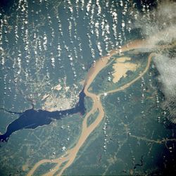 Manaus, the largest city on the Amazon, as seen from a NASA satellite image, surrounded by the muddy Amazon River and the dark Negro River.