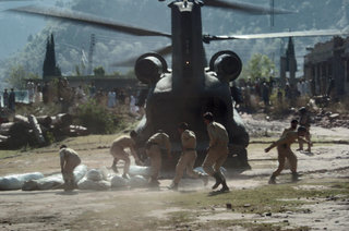 Pakistani Soldiers carry tents away from a U.S. Army CH-47 Chinook helicopter here October 19. The United States is taking part in the multinational effort to provide humanitarian assistance and support to Pakistan and Afghanistan following the devastating October 8 earthquake.