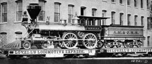 Atlantic, Mississippi and Ohio Railroad #87, delivered 1873-10-27 from the Mason Machine Works of Taunton, Massachusetts.  This is a 5 ft (1524 mm) gauge 4-4-0 with 54 in (1.37 m) drivers.  Shown during delivery on flatcars due to gauge incompatibility.  Note the elaborate ornamentation.  #87 is a wood-burner with a spark-arresting "balloon" stack.