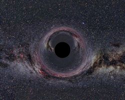 A (simulated) Black Hole of ten solar masses as seen from a distance of 600 km with the Milky Way in the background (horizontal camera opening angle: 90°).