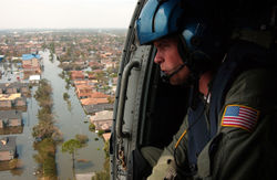 A U.S. Coast Guardsman searches for survivors in New Orleans in the aftermath of Katrina.