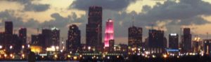 Portion of the Miami skyline showing the Bank of America tower lit hot neon pink, one of the colors that has become the epitome of Miami's fashion nostalgia.Photo: Marc Averette