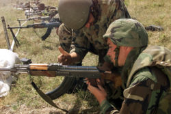 A Romanian soldier aids a U.S. Marine in clearing an RPK, a squad automatic weapon variant of the AK-47