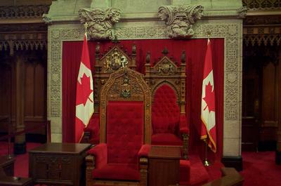 The throne and chair in the background are used by The Queen and her consort, or the Governor General and his or her spouse, respectively, during the opening of Parliament. The Speaker of the Senate employs the chair in front.