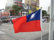 ROC flag before a busy commercial street in Taipei.