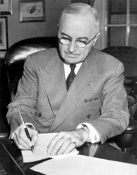 President Truman signing a proclamation declaring a national emergency that initiates U.S. involvement in the Korean War.